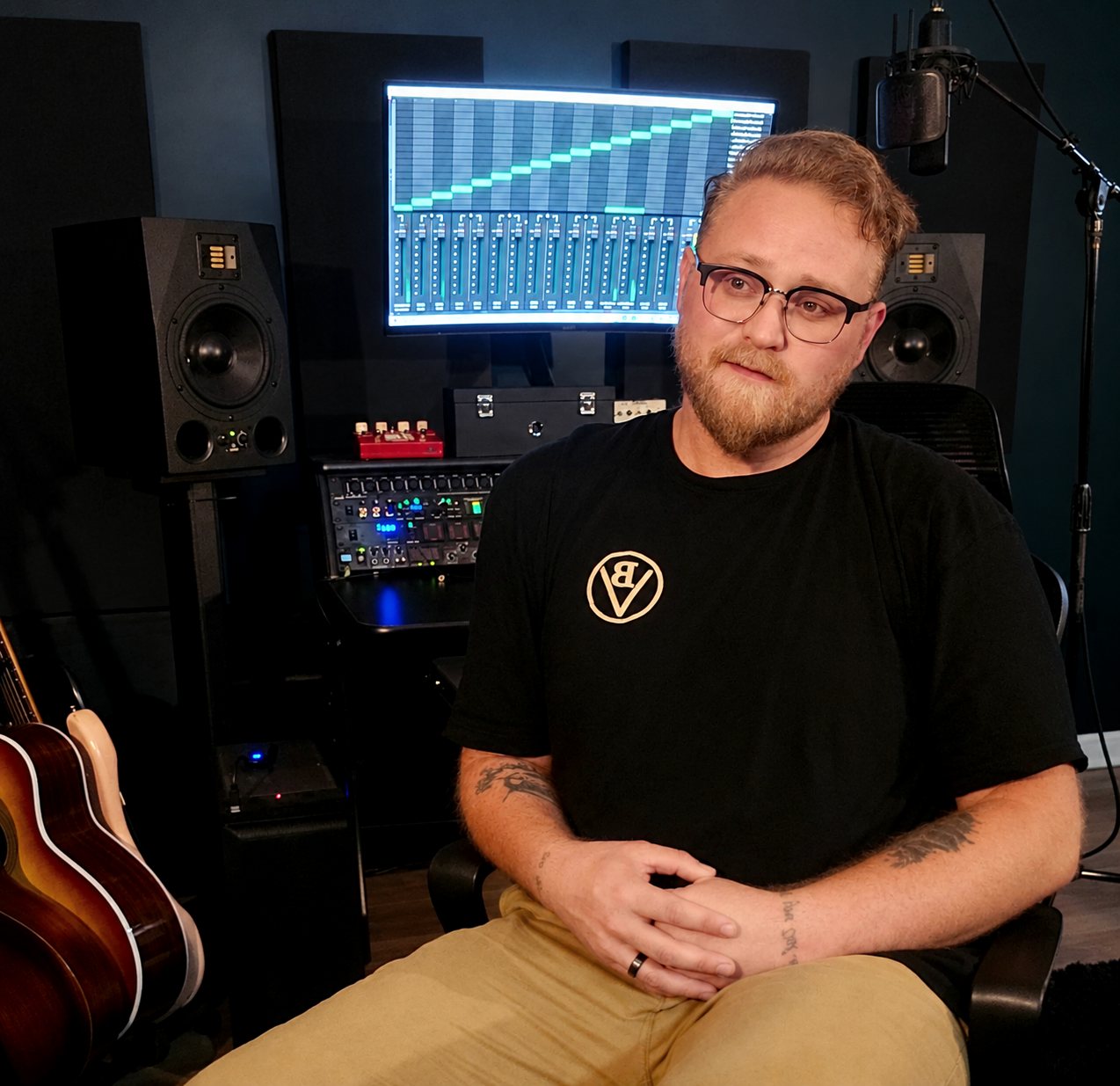 Cody Gabehart seated in the mix room, monitors and a vocal microphone behind him